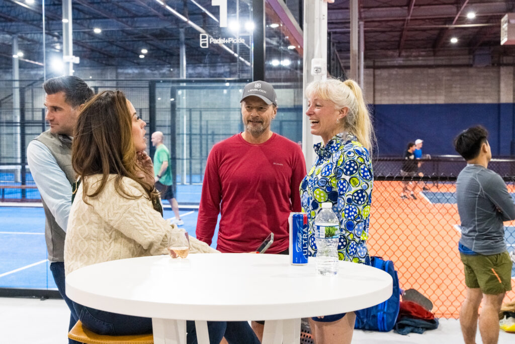People enjoying drinks and laughs at Padel + Pickle grand opening